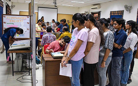 Students stand in a queue as they cast their votes for the Delhi University Students' Union (DUSU) polls 2023, at Miranda House college in New Delhi. (PTI Photo)