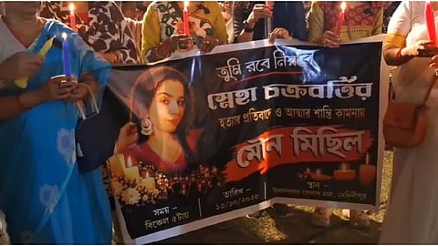 মোমবাতি ব্যানার হাতে কয়েকজন মহিলা