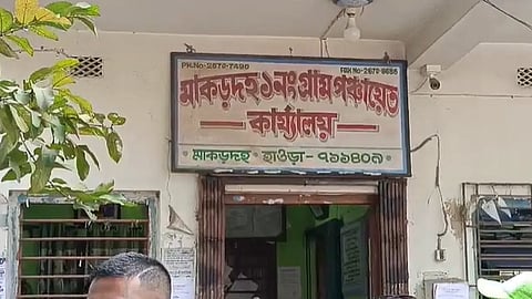 সাদা বাড়িতে একটি বোর্ডে লাল অক্ষরে লেখা