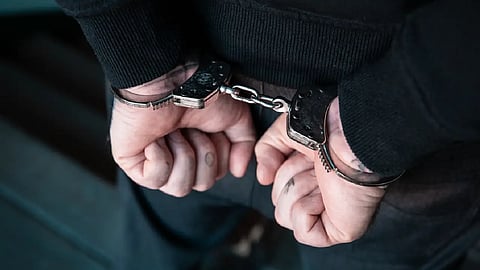 এক জনের হাতে হাতকড়া পরানো