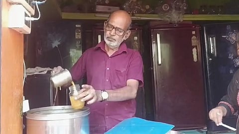 এক ব্যক্তি শিশিতে কিছু ঢালছে