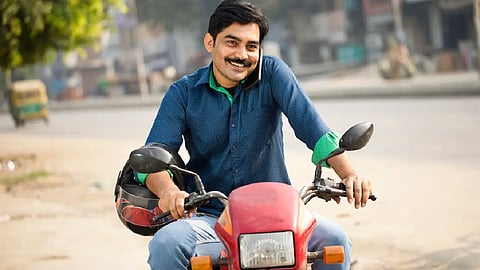 এক ব্যক্তি বিনা হেলমেটে বাইক চালাচ্ছে