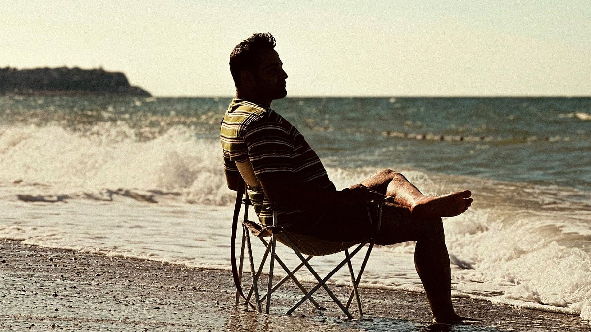 man sitting at the site of sea beach