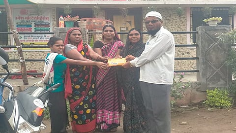 ढाकेफळ (ता.पैठण, जि.औरंगाबाद) :  पोस्टाद्वारे आलेल्या राख्याचे पाकिट एका कुंटूबाला देताना पोस्टमन रऊफभाई शेख. (छायाचित्र ज्ञानेश्वर बोरूडे)