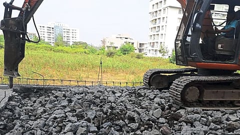 Workers removing encroachment by JCB machine.