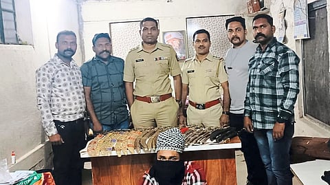 Police officers, staff with the seized swords and the suspect.