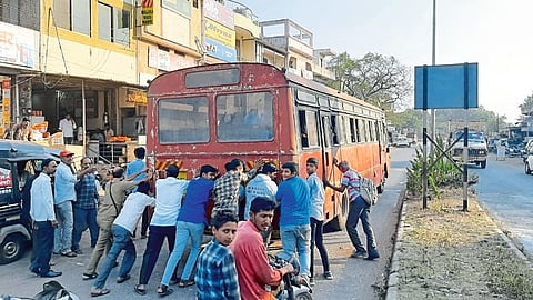 College students jostle the bus after the Khedla bus arrives at the Vinchoor stop.