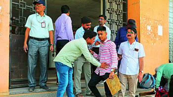 Teacher, Center Invigilator while checking and releasing the student at the examination center.