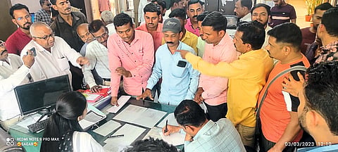 Citizens besieging the municipal officials and demanding answers regarding the stalled work on the road.