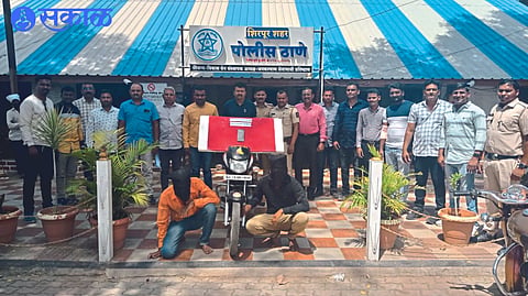 Inspector A along with mobile phone and bike seized from the suspects. S. Agarkar and Associates
