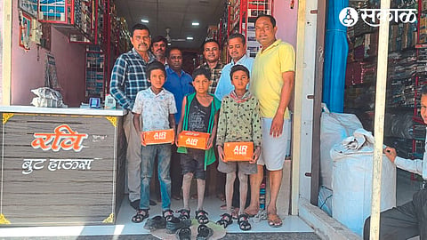 Talathi Tushar Pawar carrying shoes to children walking barefoot on the road. Neighbor Arun Desale etc.