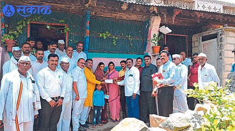 Social activist Nimba Marathe giving a check to the family of  Kalamkar who died due to electric shock