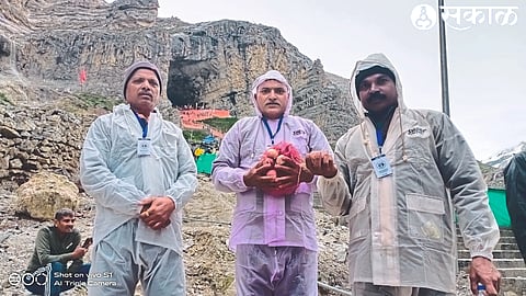 Farmer Sanjay Sathe standing with onion outside Baba Amarnath's cave.