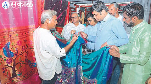 District Collector Aman Mittal while inspecting the Paithani prepared in the factory. Neighboring officers and factory directors.
