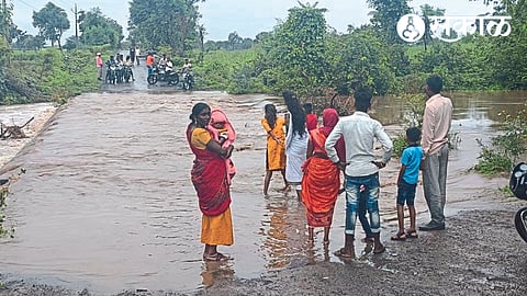 Water from the bridge near Shivpat on the Kalwadi to Devaghat road in Kalwadi, citizens on both sides.