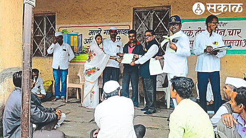 Deputy Superintendent Bhagwan Bhoye while giving the property charter to the beneficiary farmer in Dalwat, Mr. Pardeshi, Dayanand Gite etc.