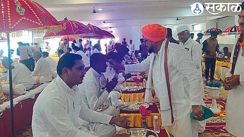 Guardian Minister Gulabrao Patil applying odor and book to the kirtans during the royal dinner.
