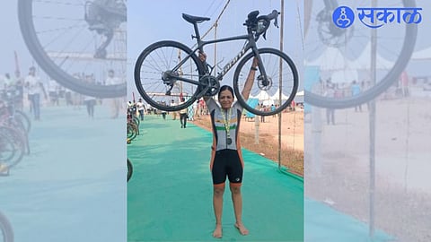 Ashwini Devere lifts her bicycle after completing the cycling distance of the International Triathlon competition held in Mangalore.