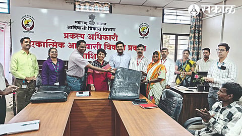 Commissioner of Tribal Development Department Nayana Gunde, Project Officer Jitin Rahman distributing tarpaulins to tribal beneficiaries