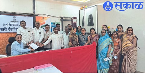 Gram Panchayat member submitting a motion of no confidence to Tehsildar Bhausaheb Thorat.
