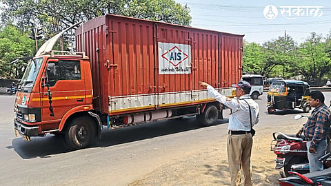 Police personnel giving instructions regarding the closure of entry for heavy vehicles.
