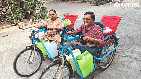 A disabled couple carrying water on a tricycle in the Vitthal Mandir area of ​​Shiv Colony.