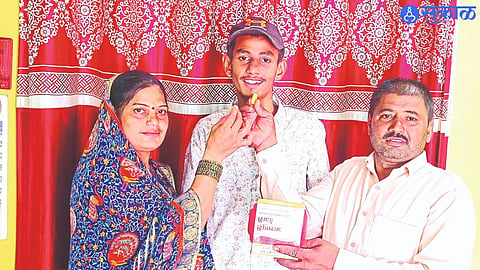 Father Namdev and mother Sunita congratulate Prasad 