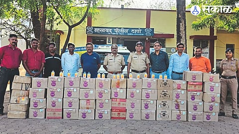 Police Inspector Rajan More and staff of Mhasavad Police Station along with seized liquor and vehicle.