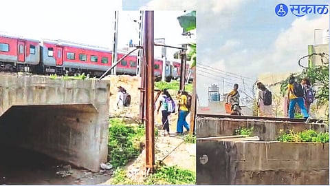 A student risked her life while crossing the railway tracks due to water puddle under the narrow bridge.