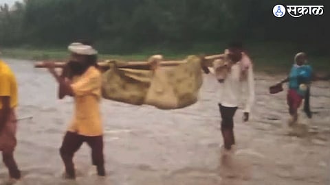 Carrying a pregnant woman to the hospital in a bamboo bag through the river water as there is no road and no ambulance.