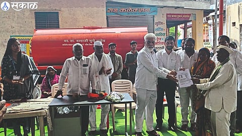 Guardian Minister Dada Bhuse while distributing seven-twelve copies to the tribal brothers.