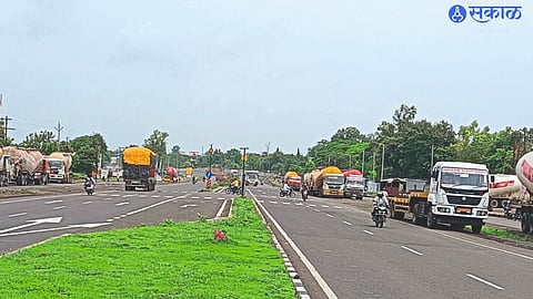 Heavy vehicles still on the service road on both sides of the highway in front of the power plant.