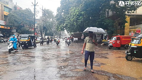 Water accumulated in front of the shop in Navi Peth. In the second photo, citizens who went out with raincoats and umbrellas for work.