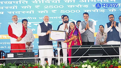 Vandana Patil of Gayatri self-help group in Jamner taluk receiving a certificate from Prime Minister Narendra Modi at the Lakhpati Didi meeting.