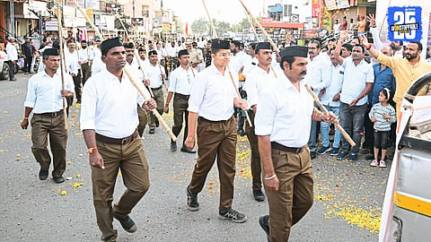 Minister Jaykumar Gore showers flowers on RSS volunteers during the centenary rally in Vaduj, Maharashtra.