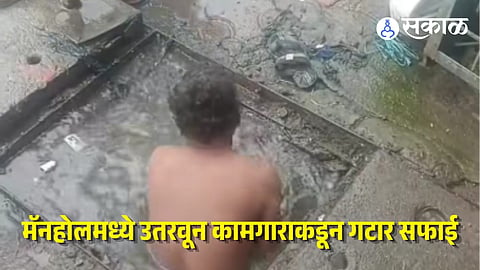 sanitation worker descend into manhole 