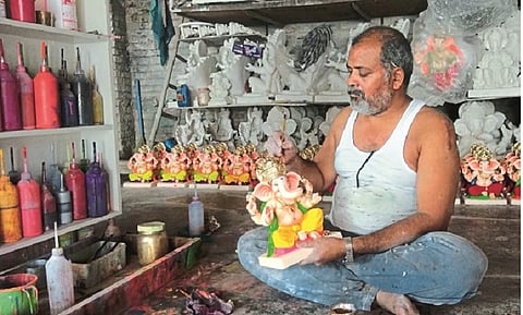 गणेशमूर्तींची रंगरंगोटी करताना मूर्तिकार. 