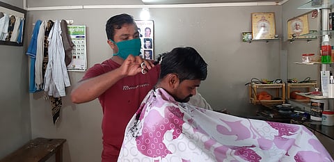टेकाडी :  दुकानात मास्क लावूनच केस कापताना दुकानदार. 