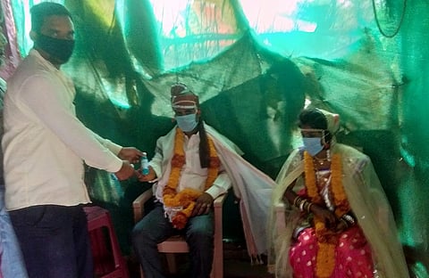 मांढळ ः नवदाम्पत्याला सॅनिटायझरची बॉटल सप्रेम भेट देताना उपसरपंच सुरेश नौकरकर. 