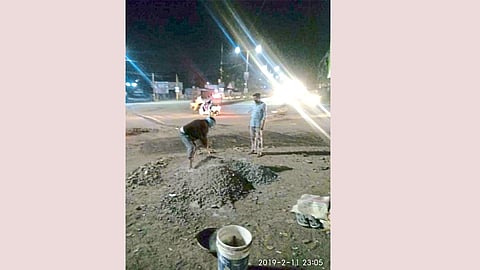 रस्त्यावरील खड्डे बुजविताना.