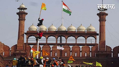 नवी दिल्ली: आंदोलक शेतकऱ्याने मंगळवारी लाल किल्ल्यावर शिखांचा पिवळा आणि केशरी झेंडा फडकवला.