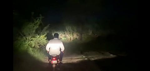 Minister Tanpur travels by bike on a narrow forest road in remote areas