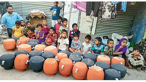 कोंढवा - कौसरबाग चाळीतील मुलांना माठांचे वाटप करताना रियाज तांबोळी.
