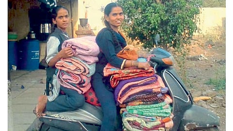 वाबळेवाडी (शिरूर) - शिवलेल्या गोधड्या दुचाकीवरून गावागावांत पोचवताना मीनाक्षी सोनकटाळे.