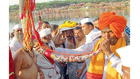 नीरा (ता. इंदापूर) - नीरास्नान आटोपल्यानंतर डोक्‍यावर पादुका घेऊन जाताना सोहळाप्रमुख.