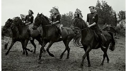 Seuran ensimmäiset edustusasut valmistettiin 1954. Seuramerkin, jossa on hevosenpää jalustimen sisällä suunnitteli Jukka Raunio. Kuvassa juniorit Kiehelän leirillä seura-asuissaan:  Tarja Sipilä, Heimo Ranta ja Erkki Ranta. 
