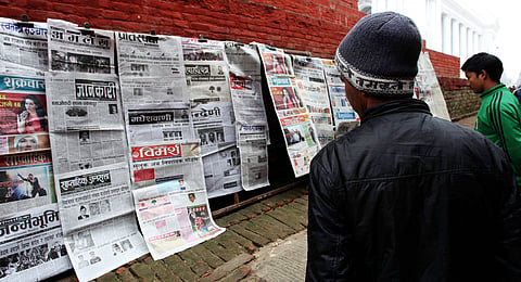 People read newspapers to get the latest update of Constituent Assembly result in Kathmandu, Nepal, November 2013. Photo: IMAGO / Xinhua. 