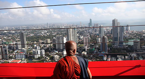 A Buddhist monk looks out at Colombo from the Lotus Tower, one of many infrastructure projects built by the Rajapaksas with Chinese loans. China’s Buddhist-to-Buddhist diplomacy seems to have been born after the Rajapaksas were ousted in 2015. Photo courtesy: NurPhoto / IMAGO