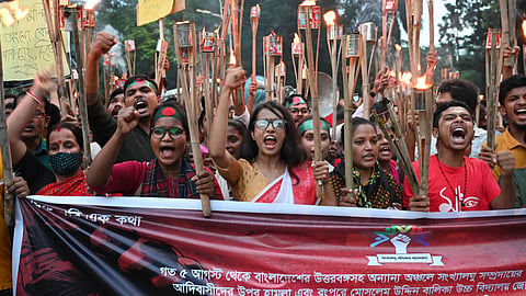 A group of Hindu protesters wearing red, carrying torches and placards, protesting anti-Hindu violence in Bangladesh