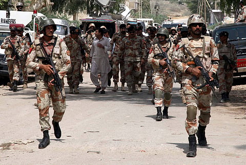 Men belonging to the Pakistan security forces in military camouflage military uniform, boots and helmets and carrying rifles during an anti-militant operation. 